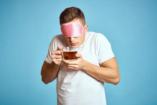 Мужчина в розовой маске для сна с чашкой чая, пьет, бодрость, модель, завтрак