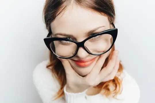 Весёлая женщина в очках улыбается на крупном плане