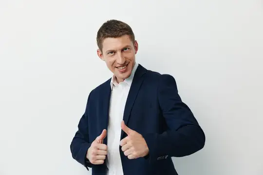 Улыбающийся мужчина в синем пиджаке показывает большие пальцы