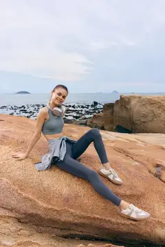 Спортивная девушка отдыхает на скалах у моря