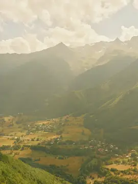 Горный пейзаж с долиной и деревней в лучах солнца