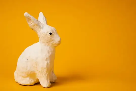 Белый пасхальный кролик на желтом фоне
