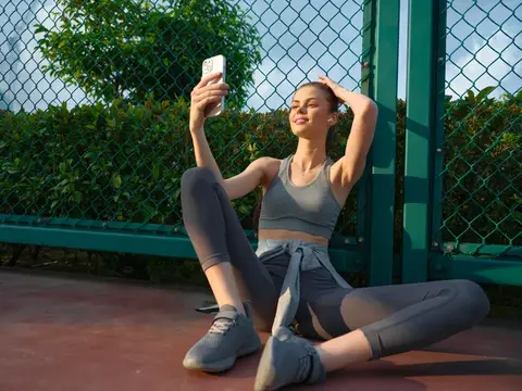 Спортивная девушка делает селфи на корте у сетки