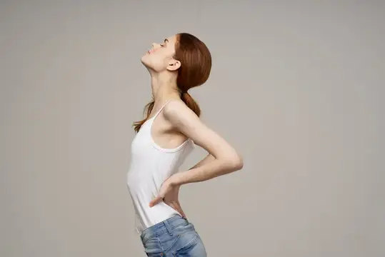 Женщина в белой футболке, боль в спине, проблемы со здоровьем, остеопороз, студийное лечение
