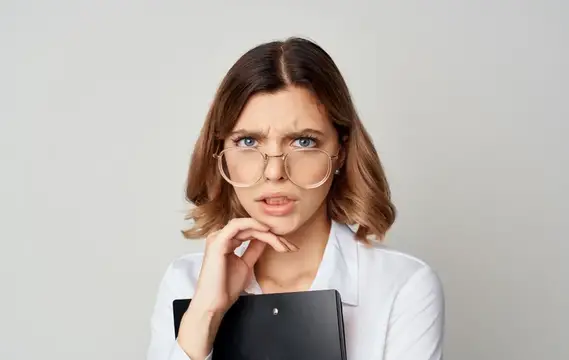 Задумчивая девушка в очках с папкой на светлом фоне