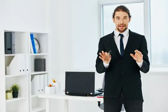 Мужчина в костюме в офисе с документами, руководитель
