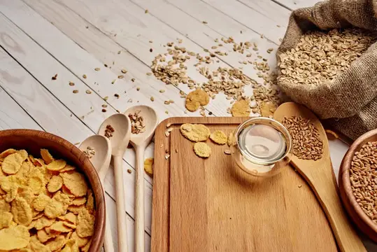 Овсяные хлопья и кукурузные палочки на светлом деревянном столе