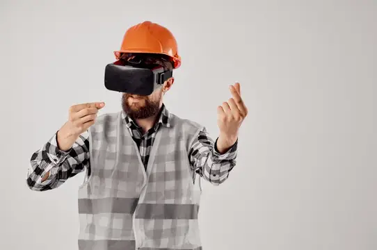 Бородатый мужчина в каске и VR-очках жестикулирует руками