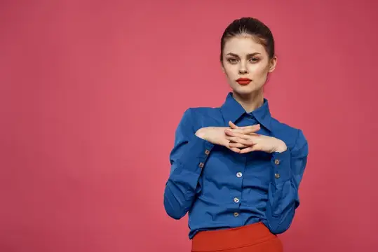Молодая женщина в синей рубашке на розовом фоне