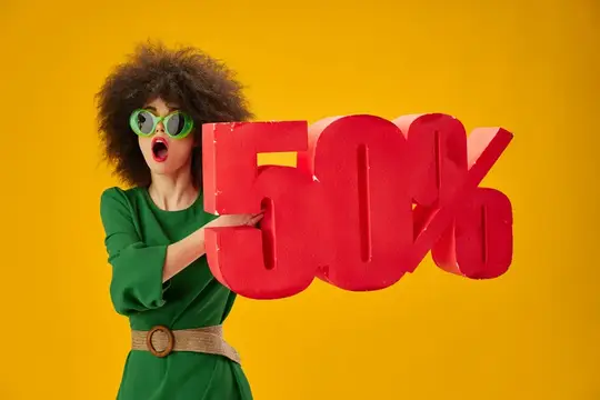 Кудрявая женщина в зелёном платье держит красную скидку 50%