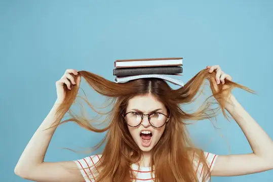 Рыжеволосая девушка в очках с книгами на голове в отчаянии