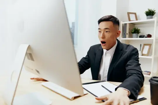 Менеджер работает за компьютером, рядом стоит стакан кофе