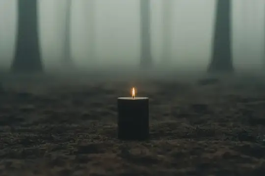Горящая свеча на земле в туманном лесу