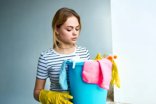 Женщина-домохозяйка использует ведра и тряпки для уборки