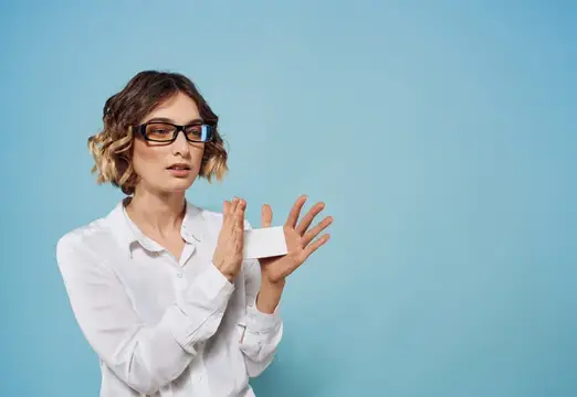 Женщина держит визитную карточку на синем фоне