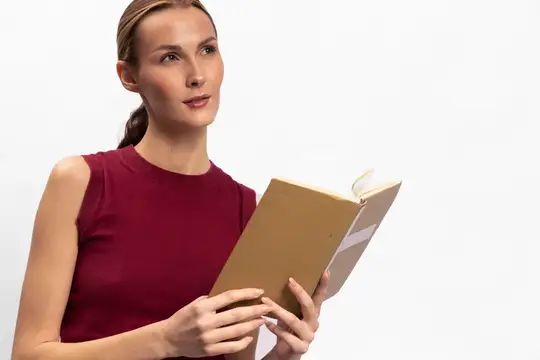 Молодая женщина с книгой в руках задумчиво смотрит в сторону