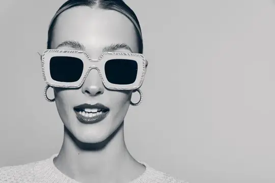 Улыбающаяся женщина в больших белых солнцезащитных очках