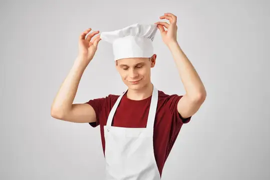 Мужчина в фартуке профессионально работает на кухне