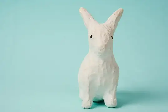Праздничная игрушка — белый кролик на голубом фоне в пастельных тонах