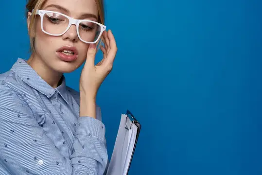 Деловая женщина блондинка в очках с документами работает в синей рубашке