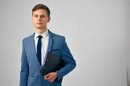 Деловой мужчина в костюме, излучающий уверенность в себе, работает с документами в офисе