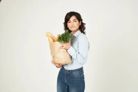 Женщина с пакетом продуктов в супермаркете