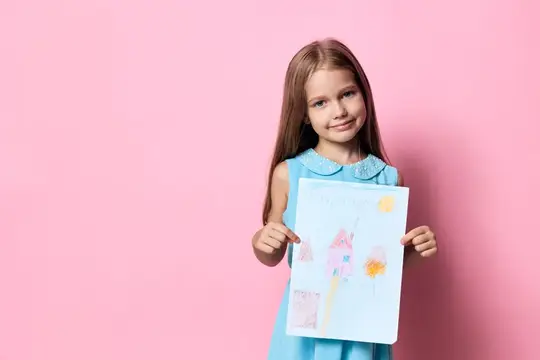Девочка с длинными волосами показывает детский рисунок на розовом фоне