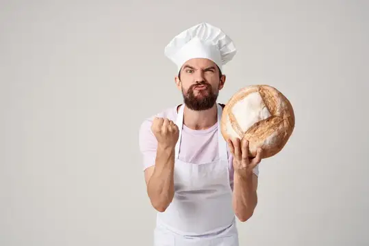 Мужчина в униформе пекаря готовит хлеб