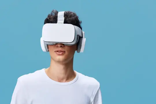Молодой человек в белом VR-шлеме на голубом фоне