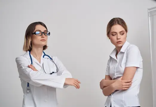 Две женщины-медика в белых халатах выясняют отношения