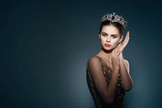 На фотографии изображена красивая женщина с короной на голове, ярким макияжем и роскошными украшениями