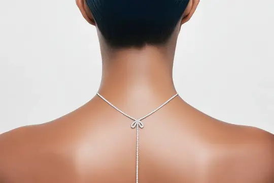 Серебристое колье с бантом на шее темнокожей женщины