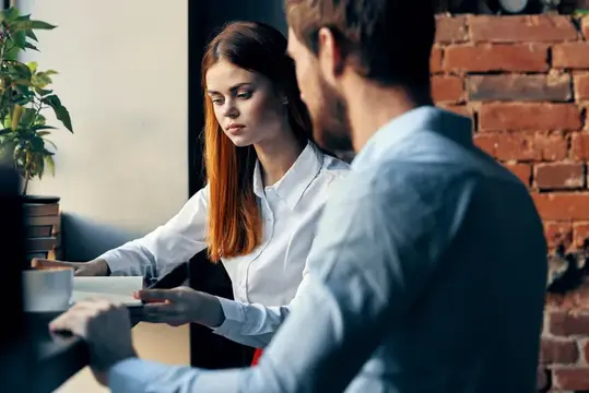 Деловой мужчина и женщина сидят за столом, работа, общение, офис