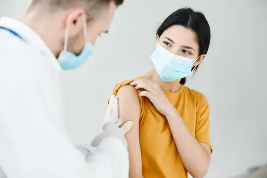 Медсестра делает укол в плечо женщине, вакцинация, инфекция, эпидемия