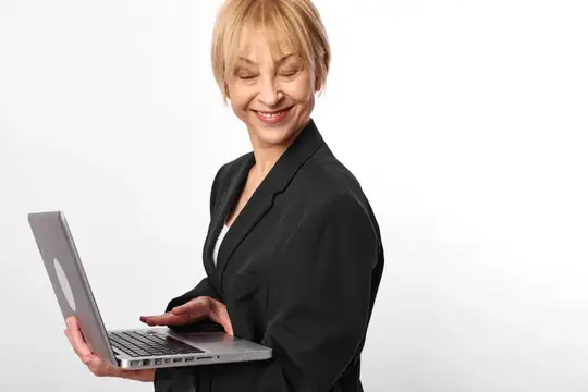 Улыбающаяся блондинка в деловом костюме держит ноутбук