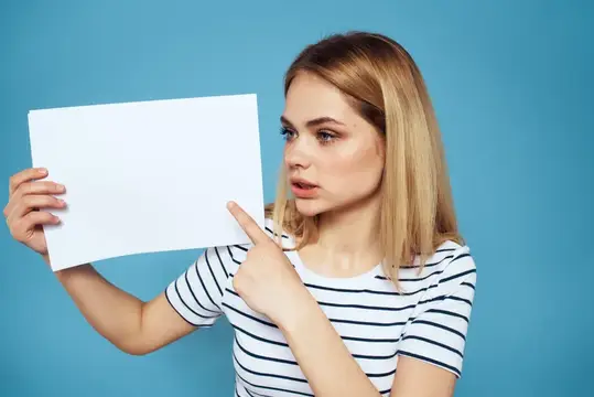 Женщина держит лист бумаги, на ней полосатая футболка