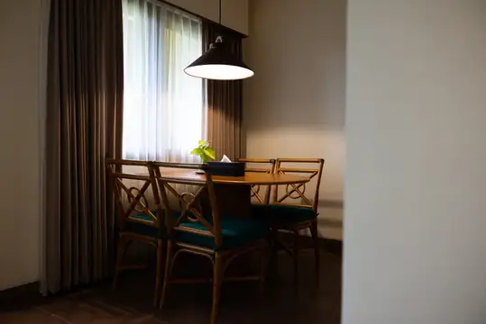 Уютный обеденный стол с бамбуковыми стульями у окна