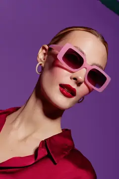 Светловолосая девушка в розовых очках на фиолетовом фоне