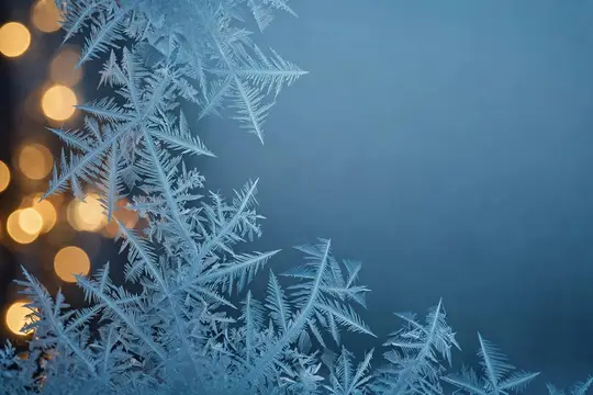 Морозные узоры на синем стекле с тёплыми огнями на фоне