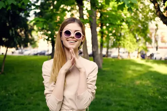 Весёлая женщина гуляет по парку по зелёной траве летом