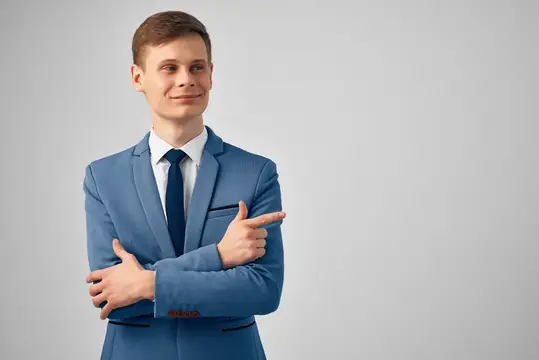Молодой человек в синем костюме показывает рукой в сторону