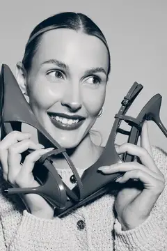 Улыбающаяся женщина с туфлями на каблуках у лица