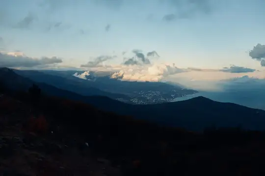 Горный пейзаж с долиной и облаками в сумерках
