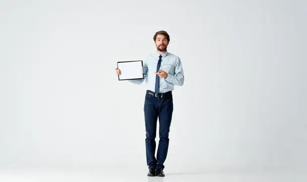 Бородатый мужчина в рубашке с галстуком работает с бумагами в офисе