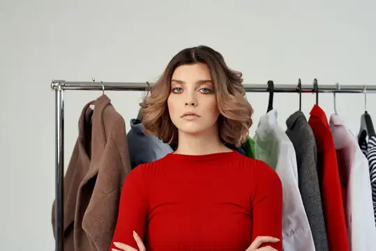 Жизнерадостная женщина рядом с одеждой, мода, веселье, розничная торговля, эмоции