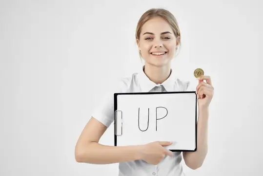 Женщина держит папку с надписью «up» — криптовалюта, финансы