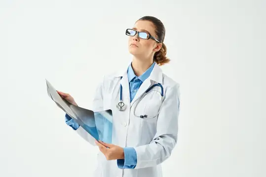 Врач в белом халате и очках изучает медицинские документы