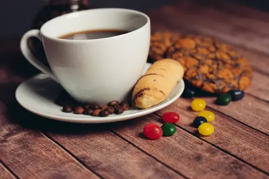 Чашка кофе, печенье, сладости на деревянном столе — закуска