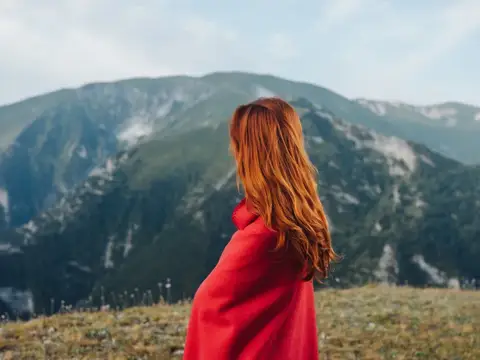 Женщина в красной клетчатой рубашке в горном пейзаже, на природе, в стиле лайфстайл