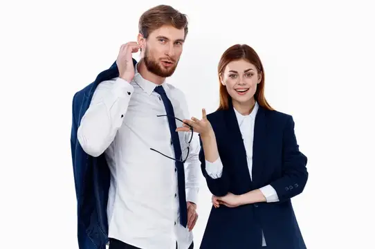 Улыбающиеся мужчина и женщина в деловых костюмах на белом фоне